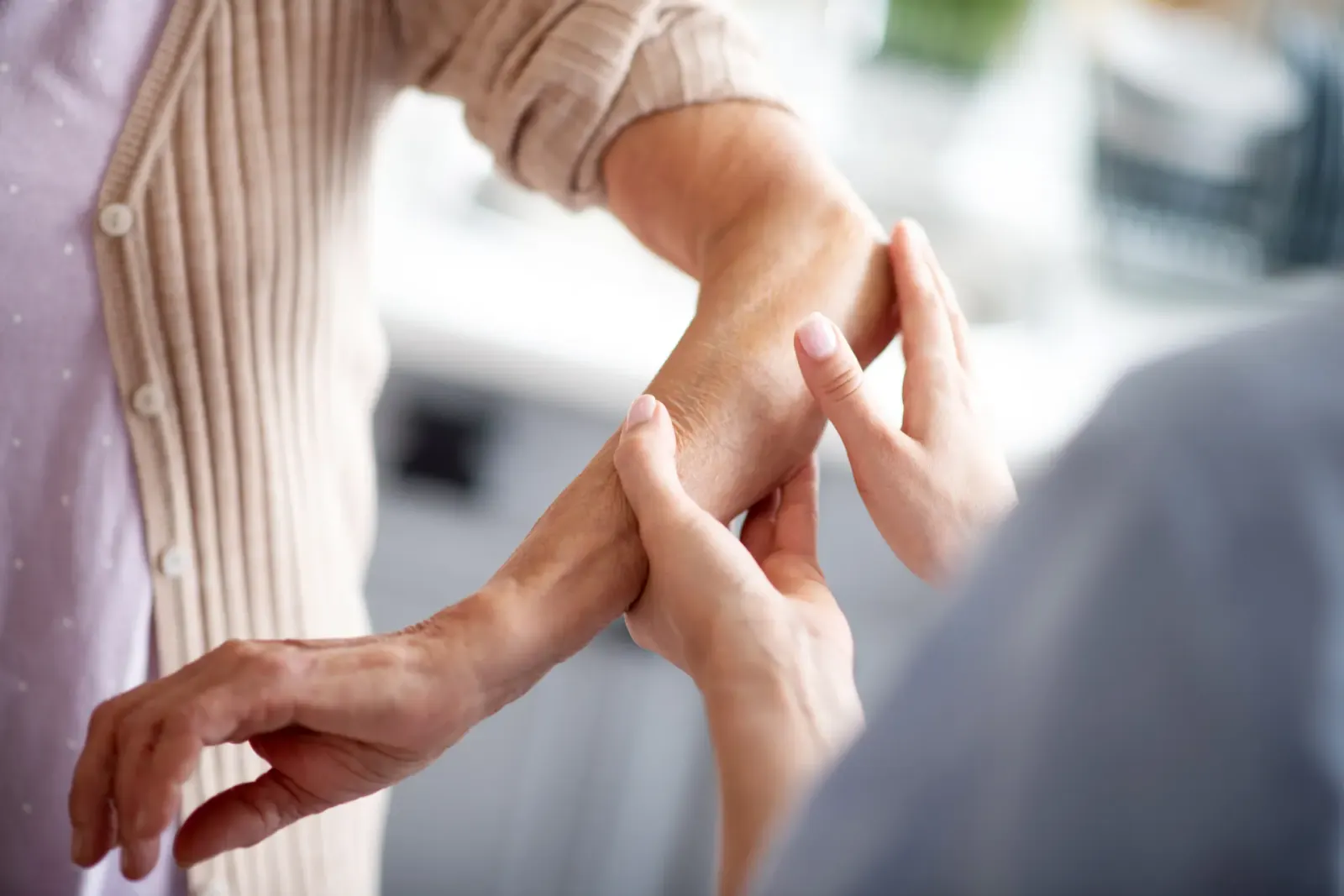 Caregiver applying cream to an older person's forearm
