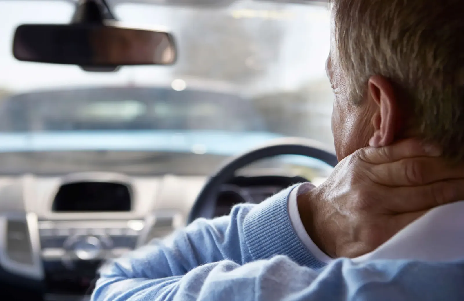 Driver holding the back of his neck in pain