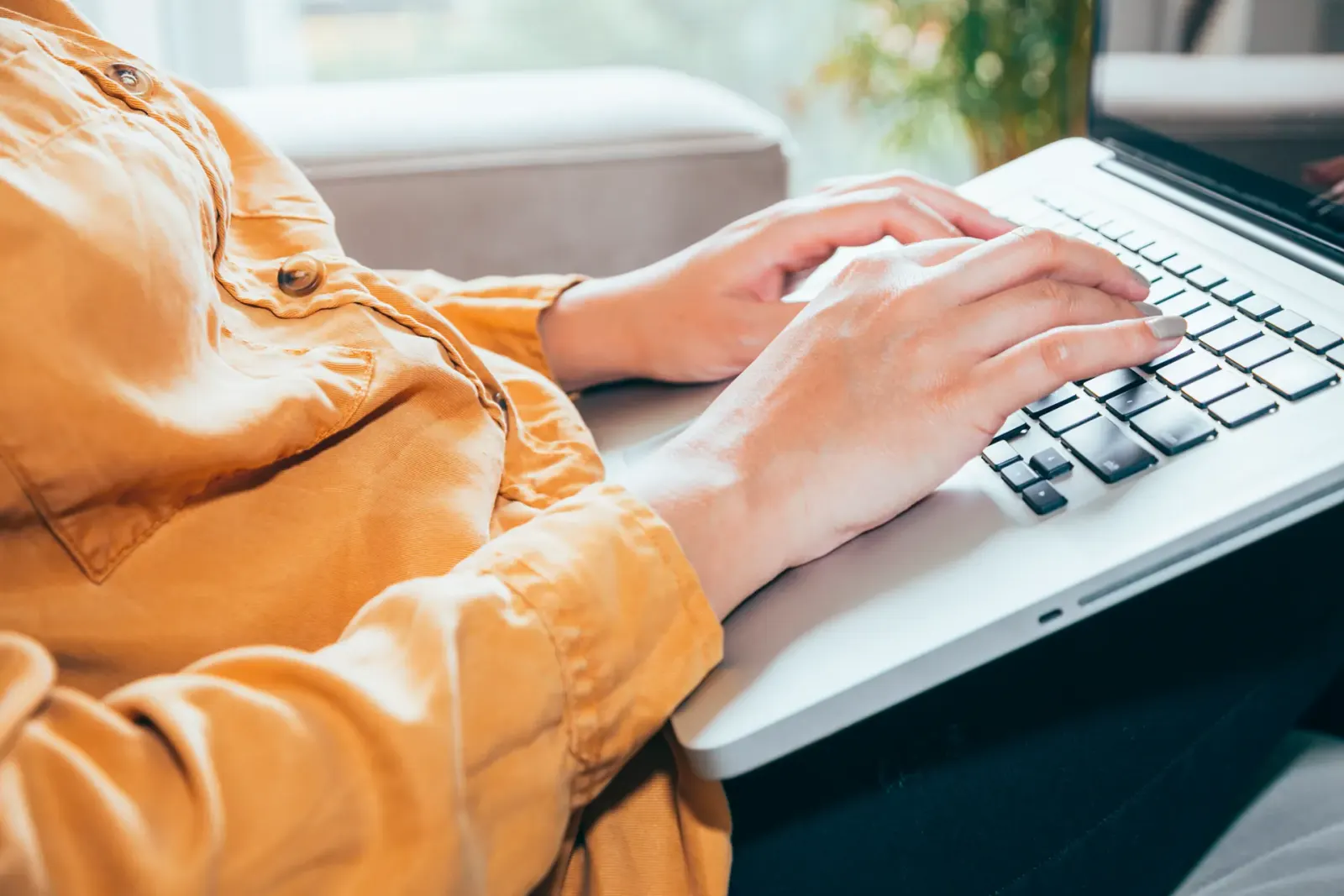 Hands typing on a laptop keyboard