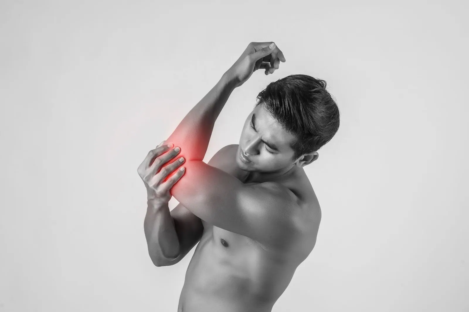 Man holding his elbow with the painful area highlighted in red