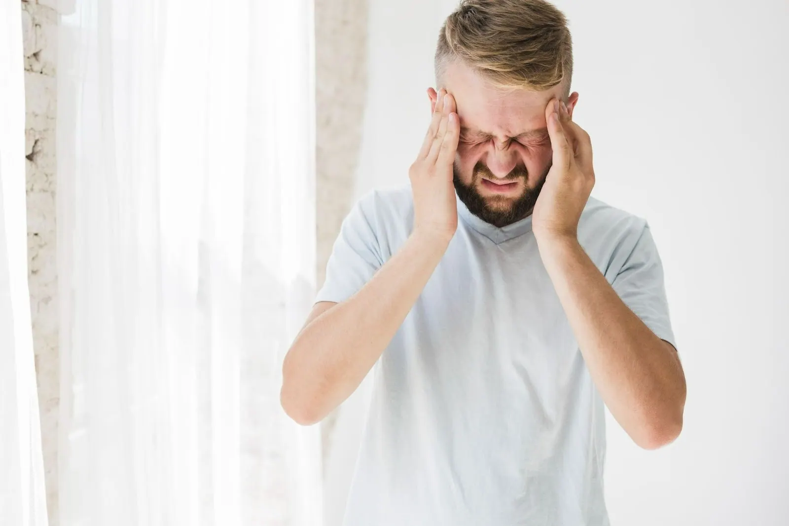 Man holding his temples with a headache