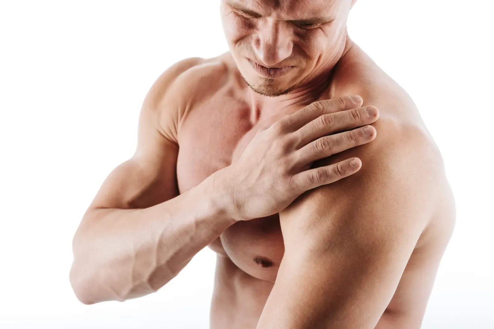 Shirtless man holding his shoulder in pain