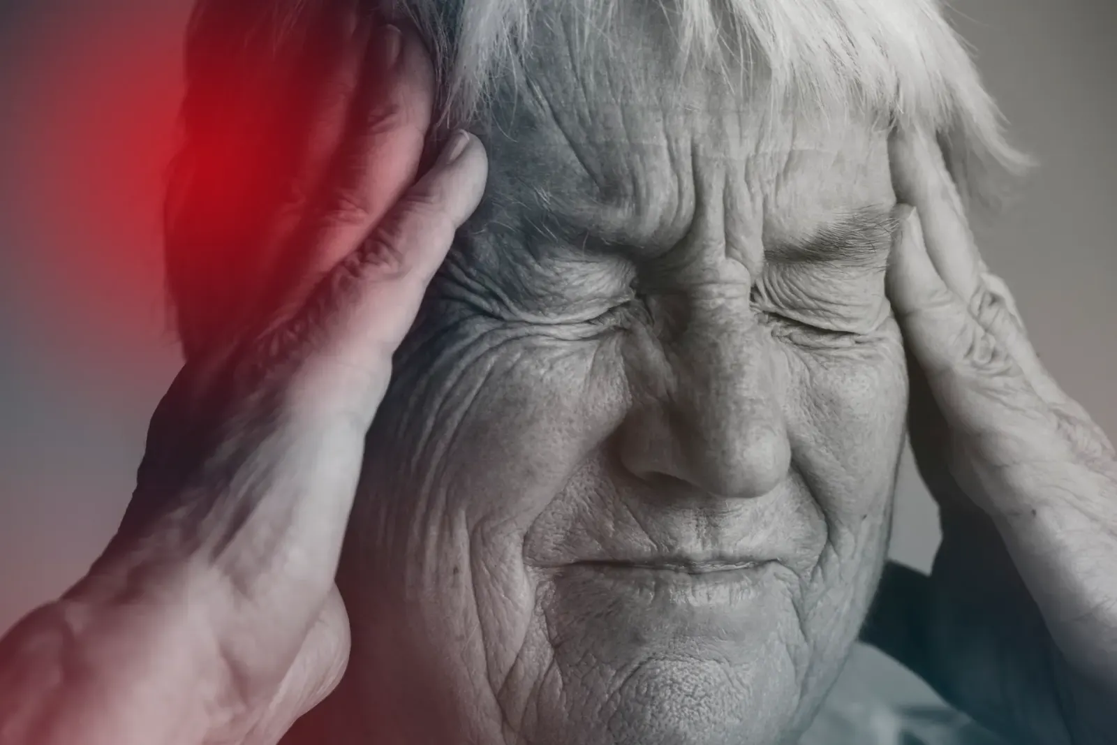 Older woman holding her head with a pained expression