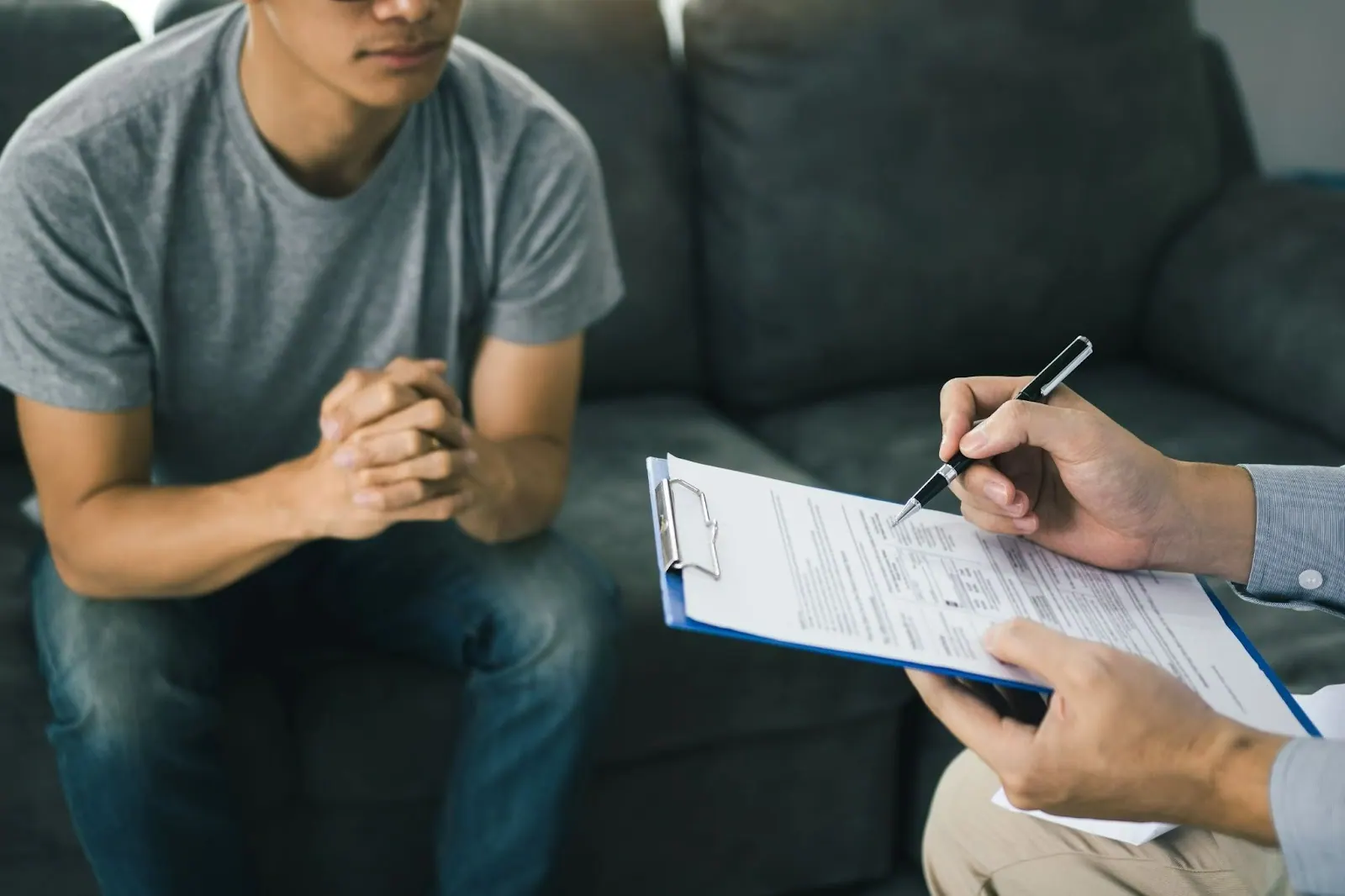 Patient talking with a practitioner who takes notes on a clipboard