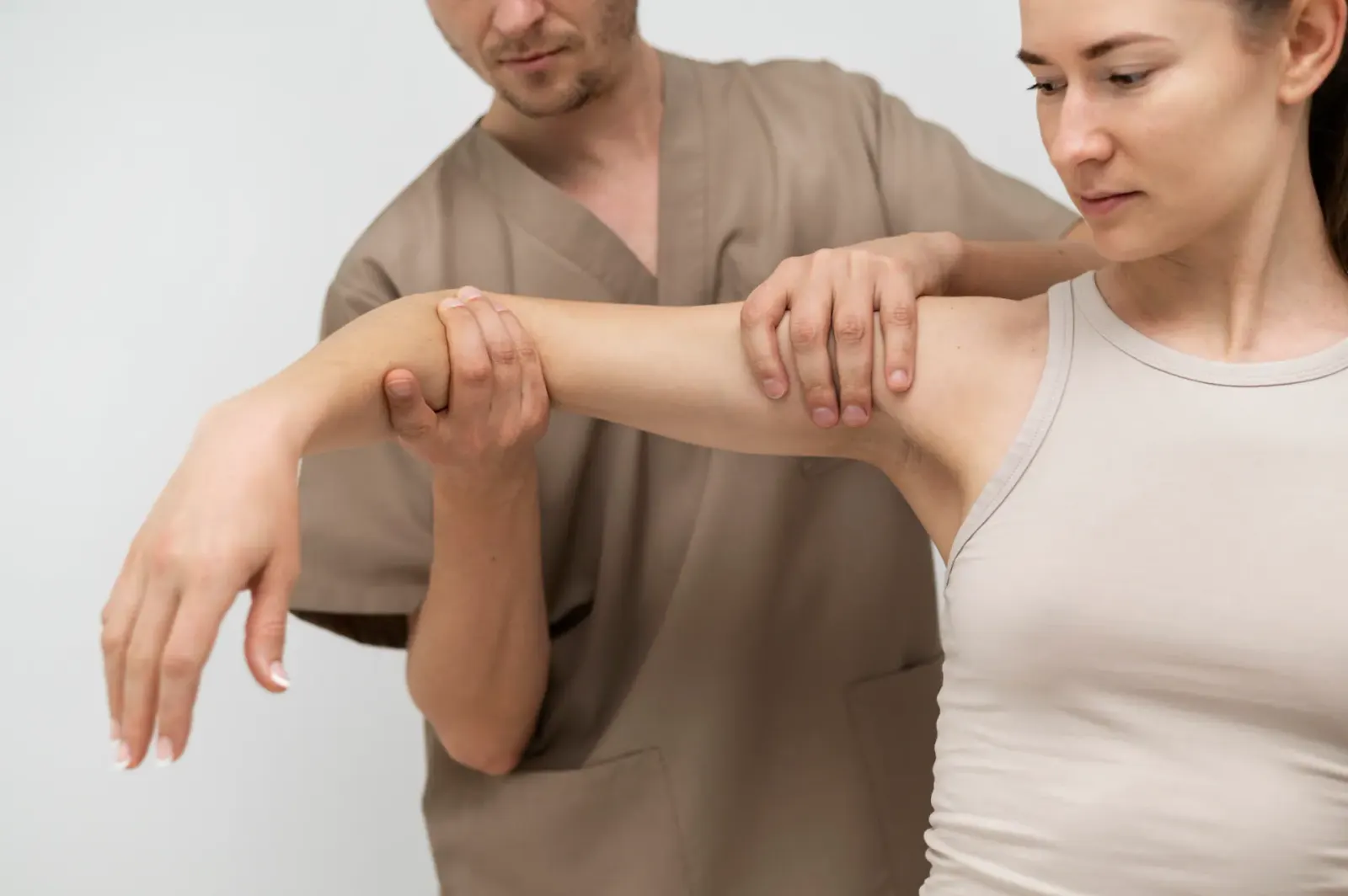Practitioner assessing a woman's shoulder mobility