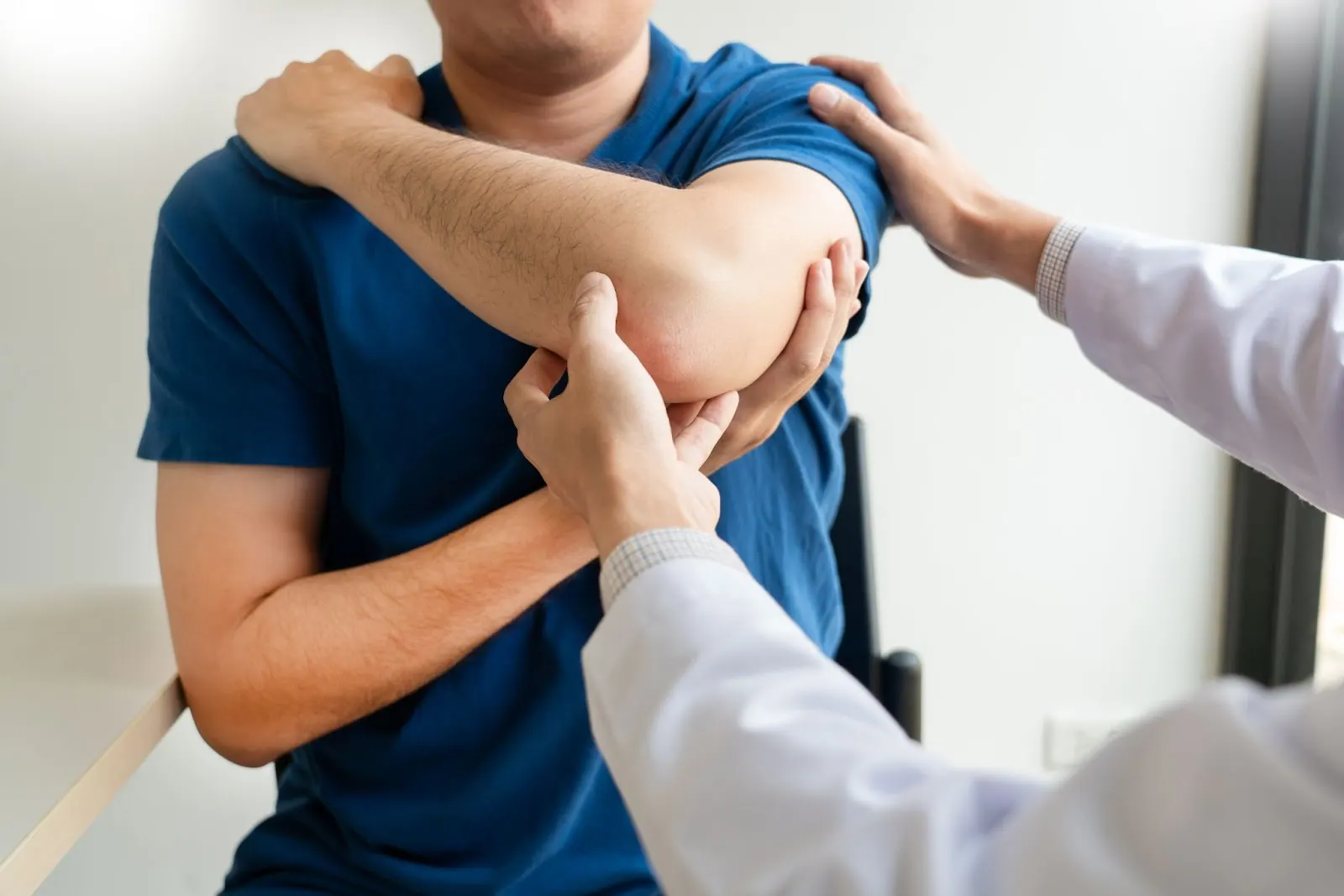 Practitioner examining a patient's elbow and shoulder