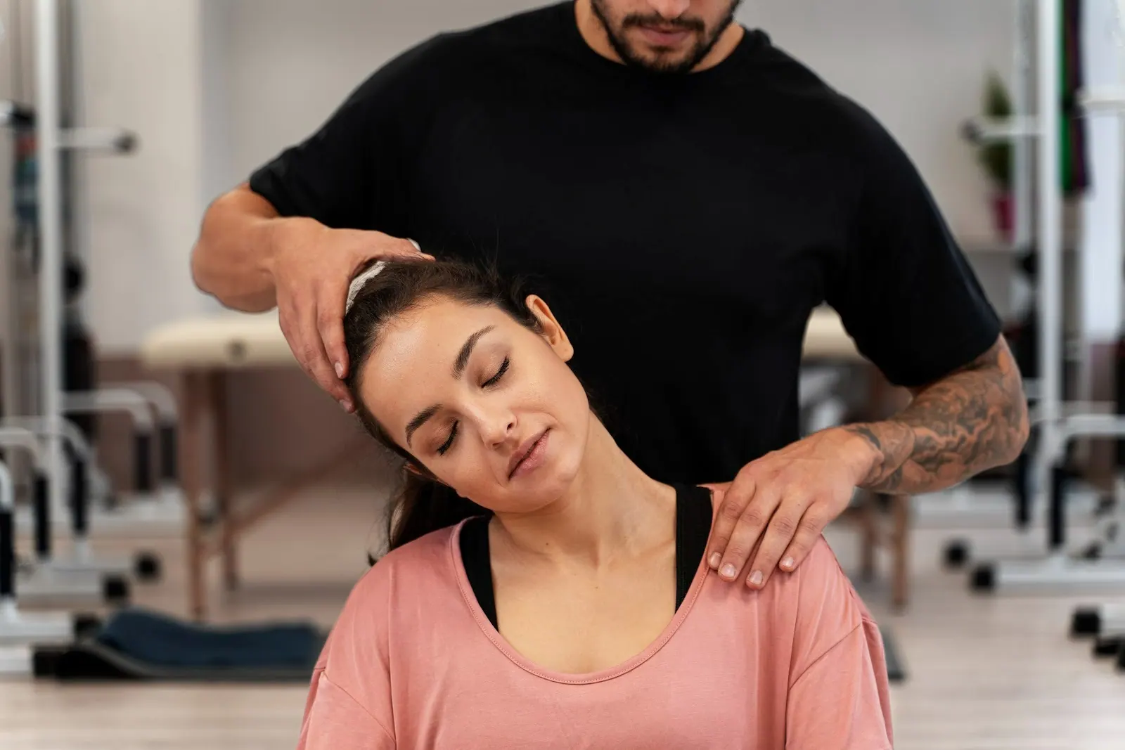 Practitioner stretching a seated woman's neck