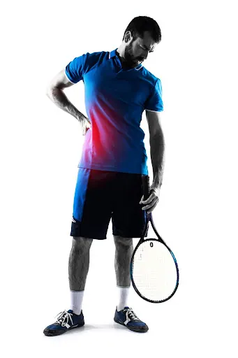 Tennis player holding his lower back with the painful area highlighted