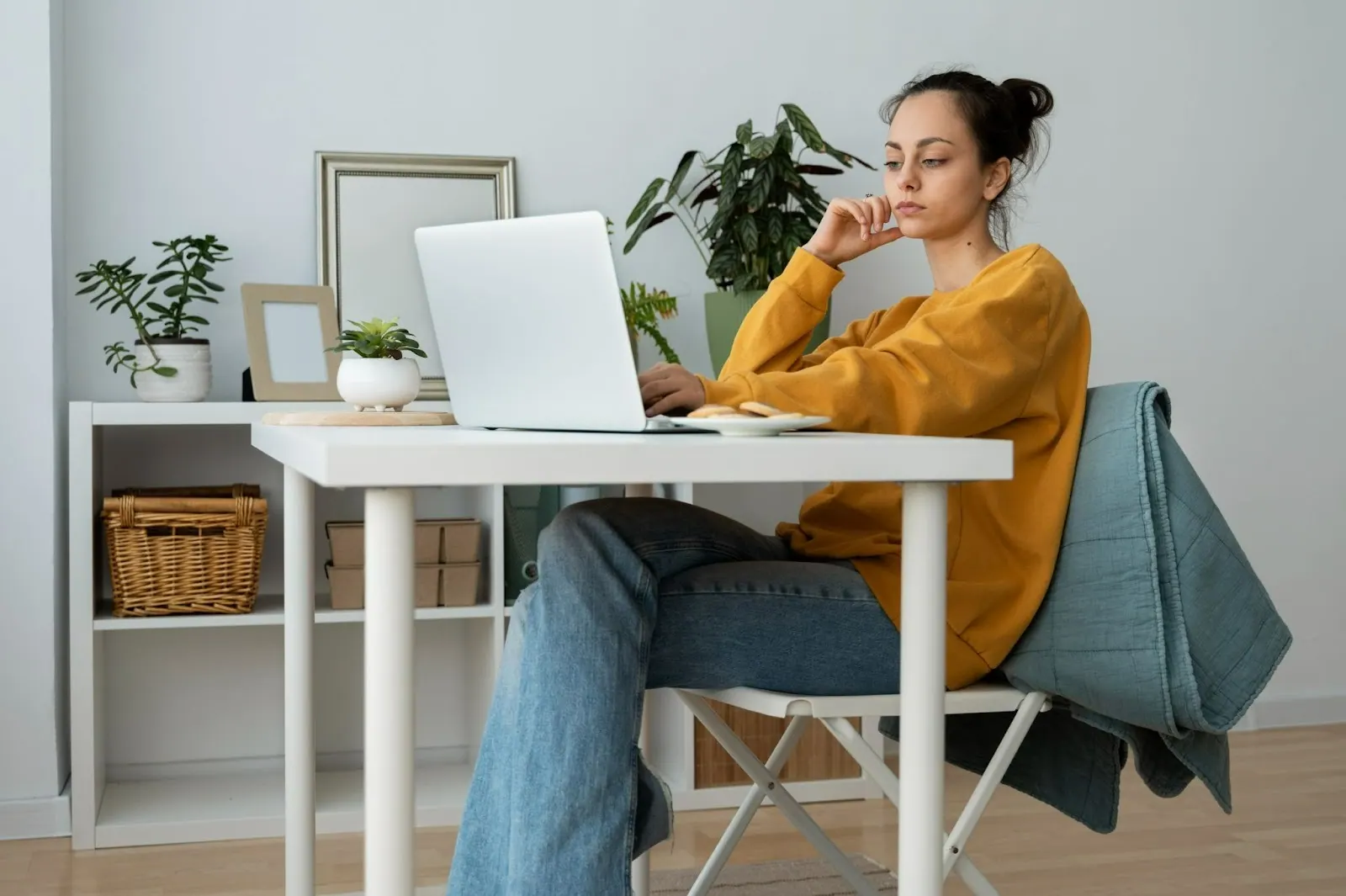 Woman sitting at a home desk with a laptop