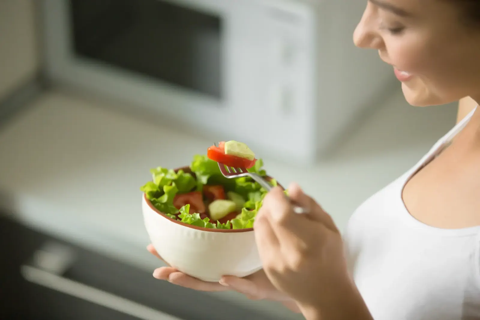 Woman holding a bowl of fresh salad