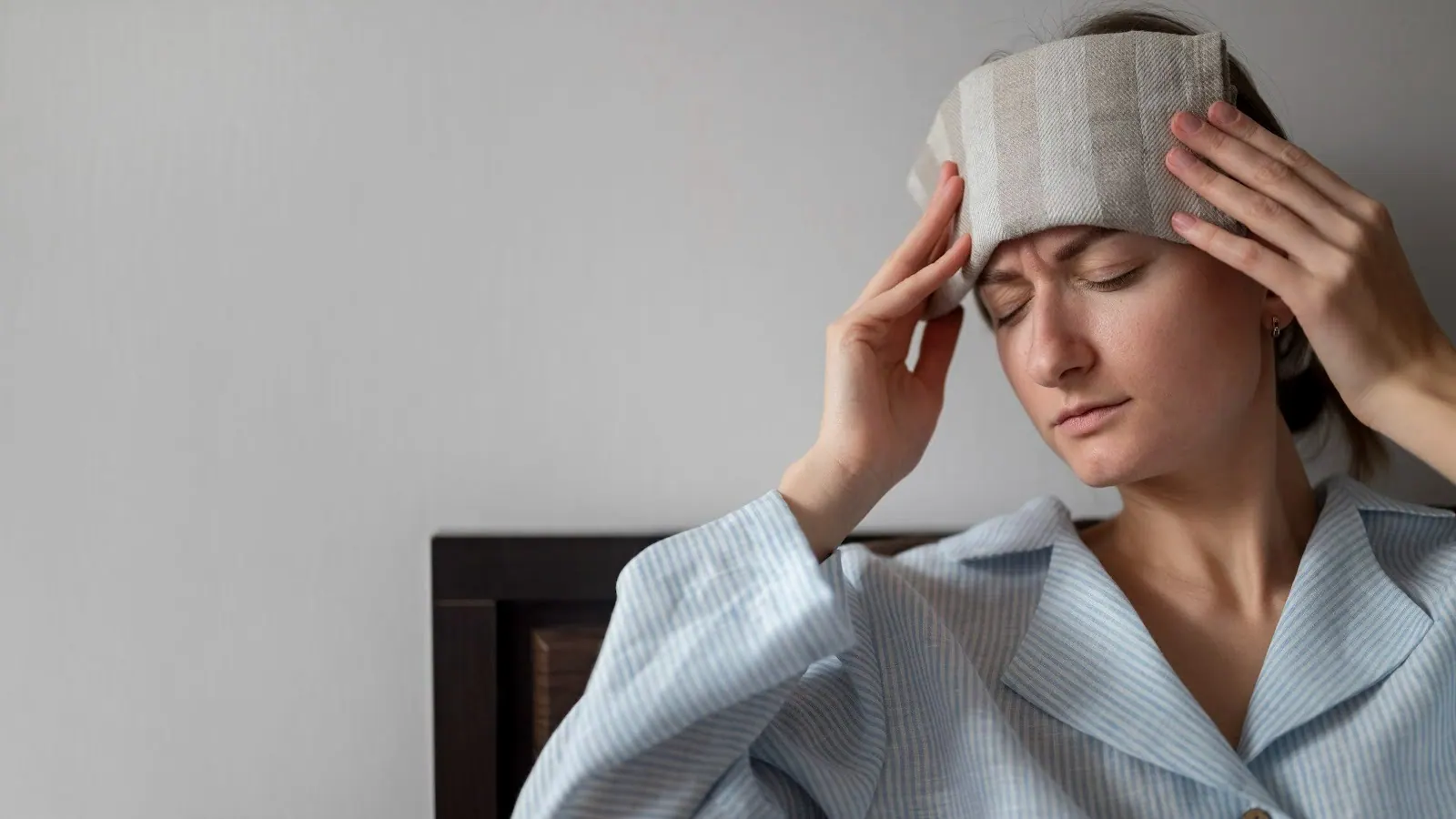 Woman holding a cold compress to her forehead