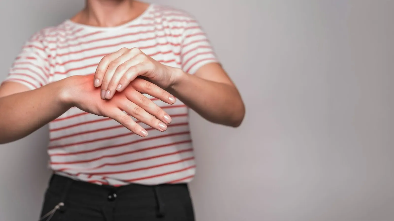 Woman holding her wrist with the painful area highlighted in red