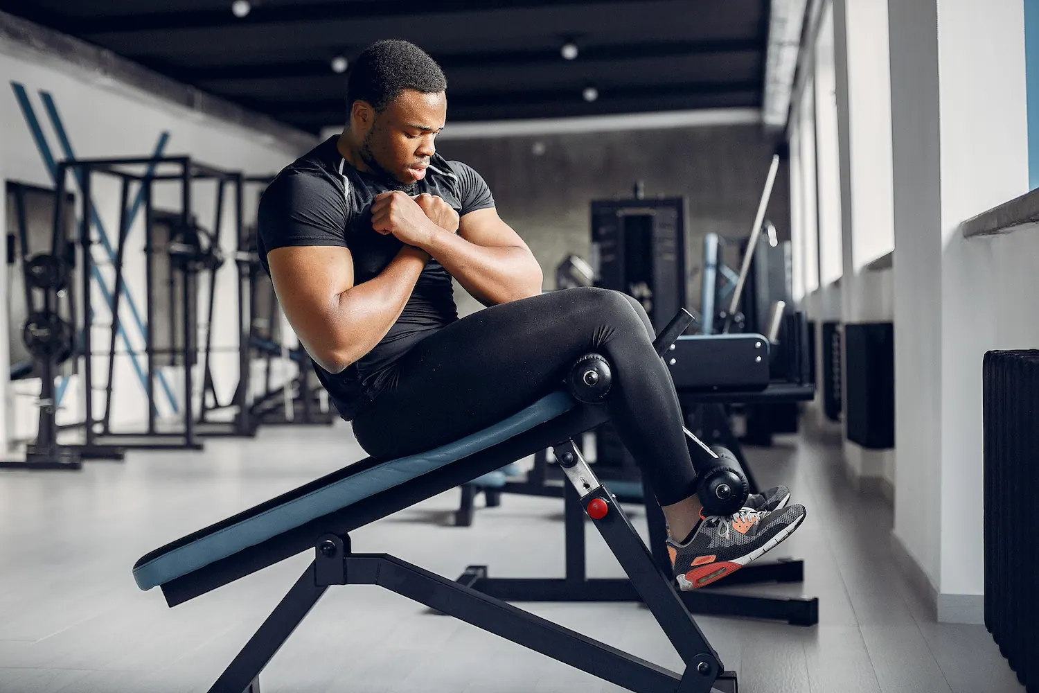 Man doing a sit-up on an incline bench in a gym