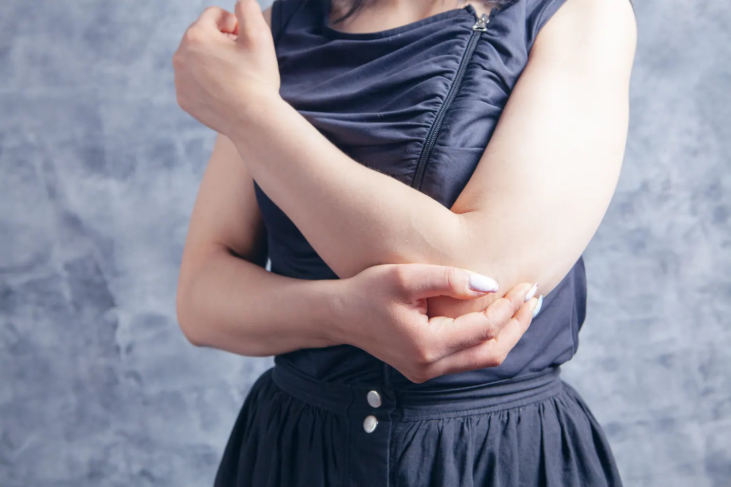 Woman holding her elbow