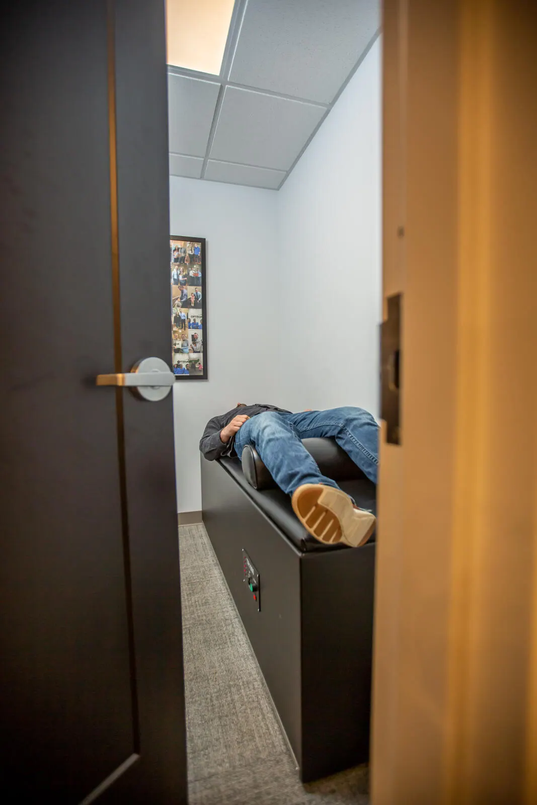 Patient lying on an intersegmental traction table, seen through an open doorway