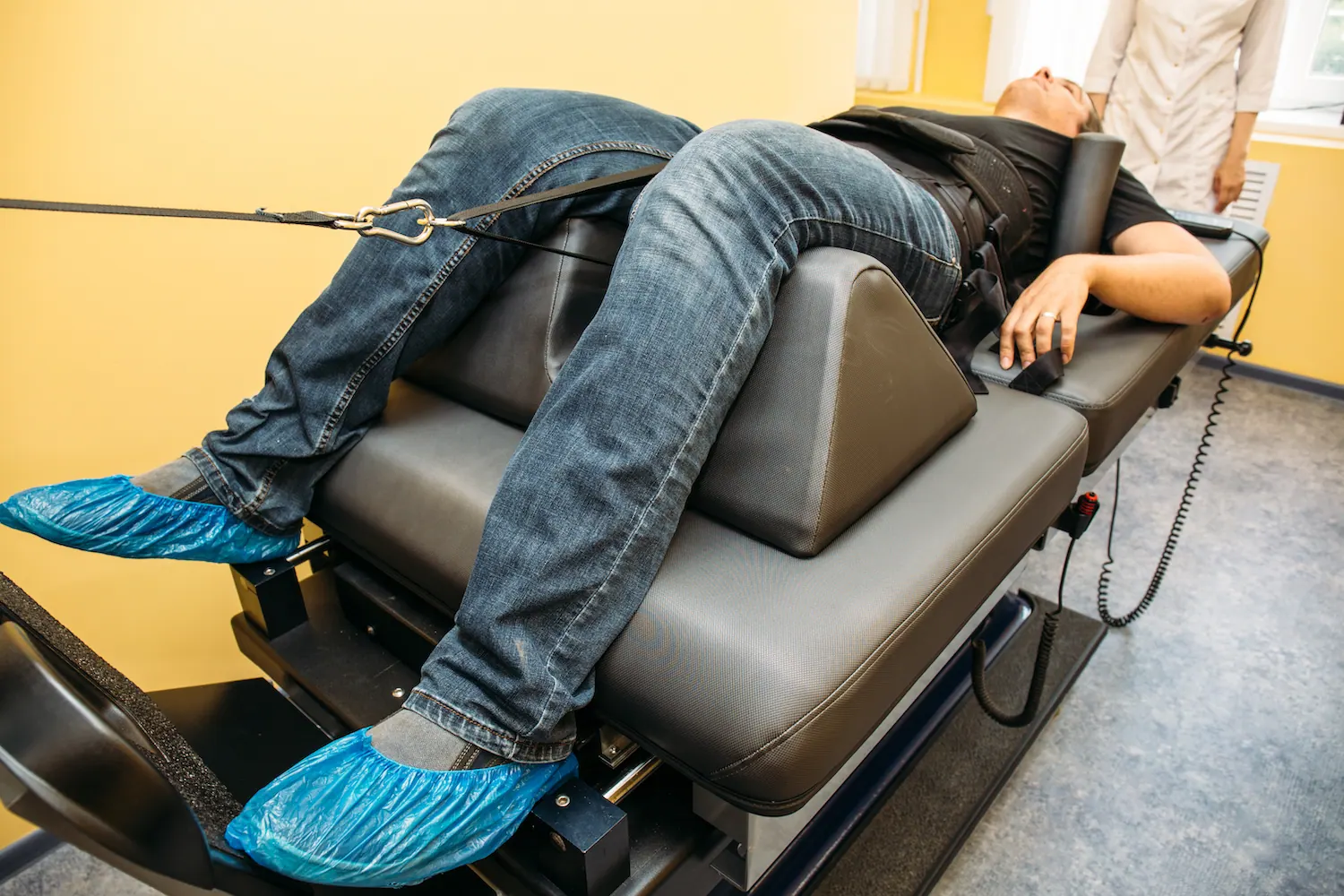 Patient lying on a spinal decompression table with a harness