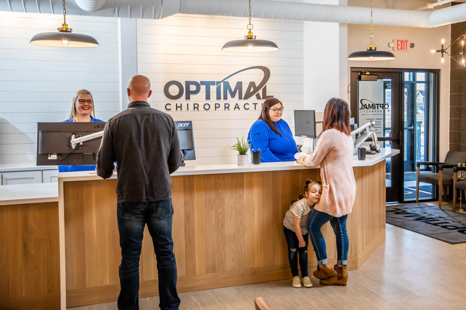 Family checking in at the Optimal Chiropractic front desk