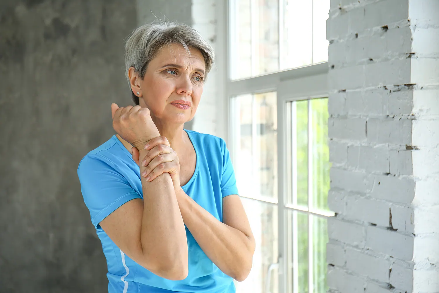 Older woman holding her wrist