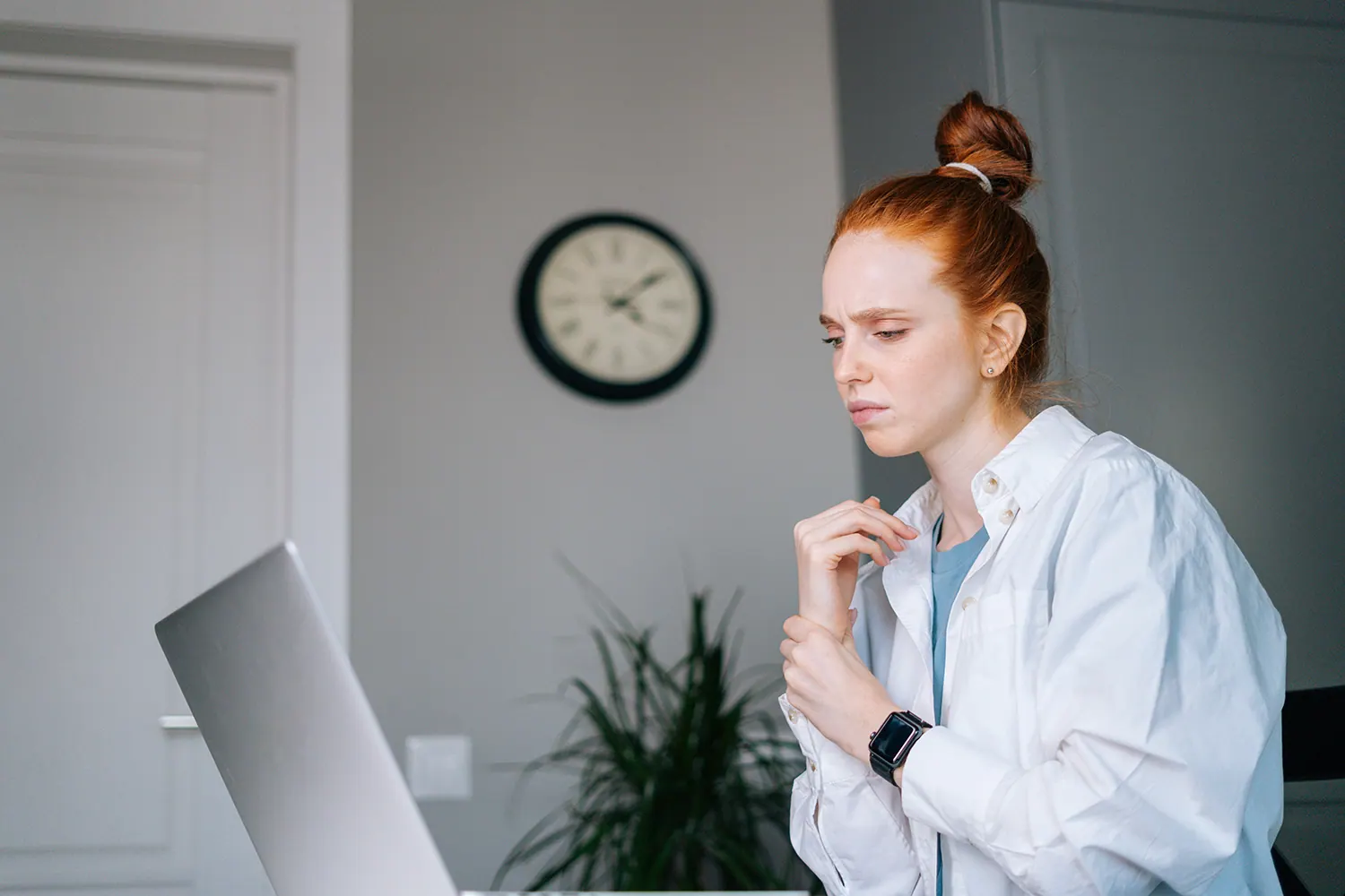Woman at a desk holding her wrist
