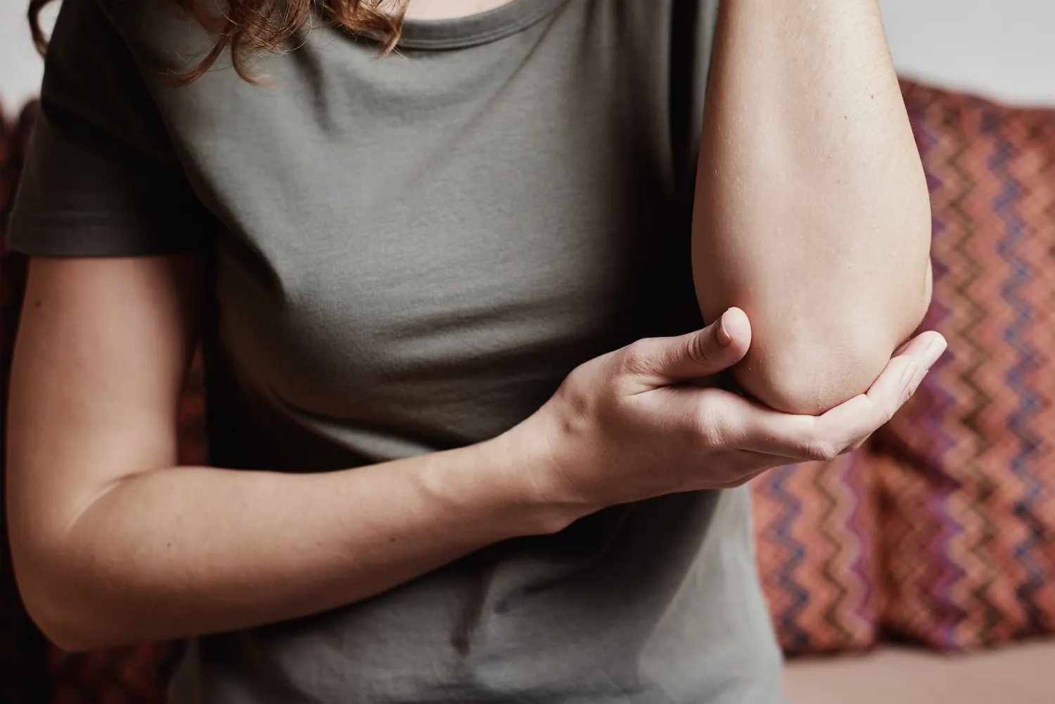 Woman holding her elbow