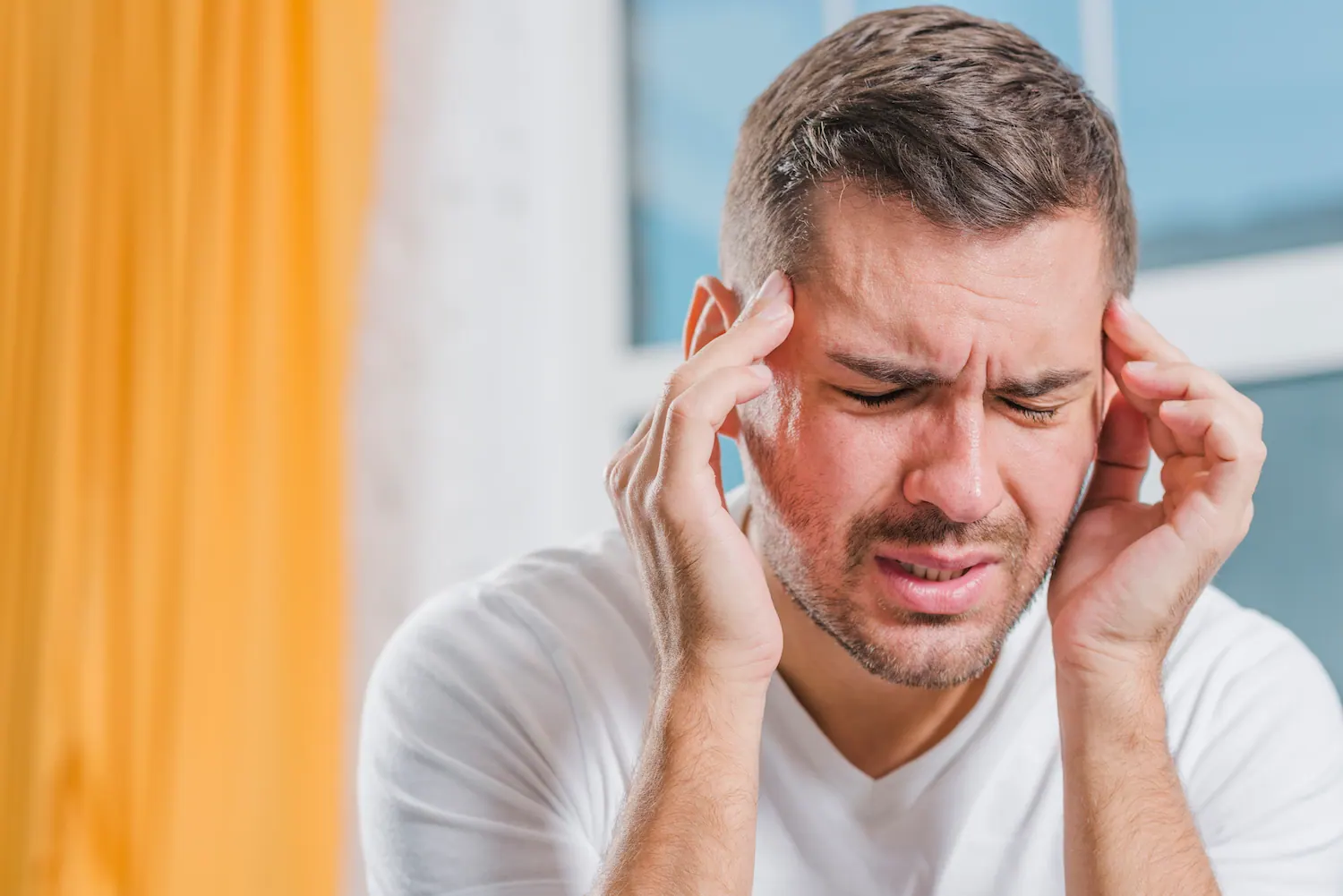 Man holding his temples with a headache