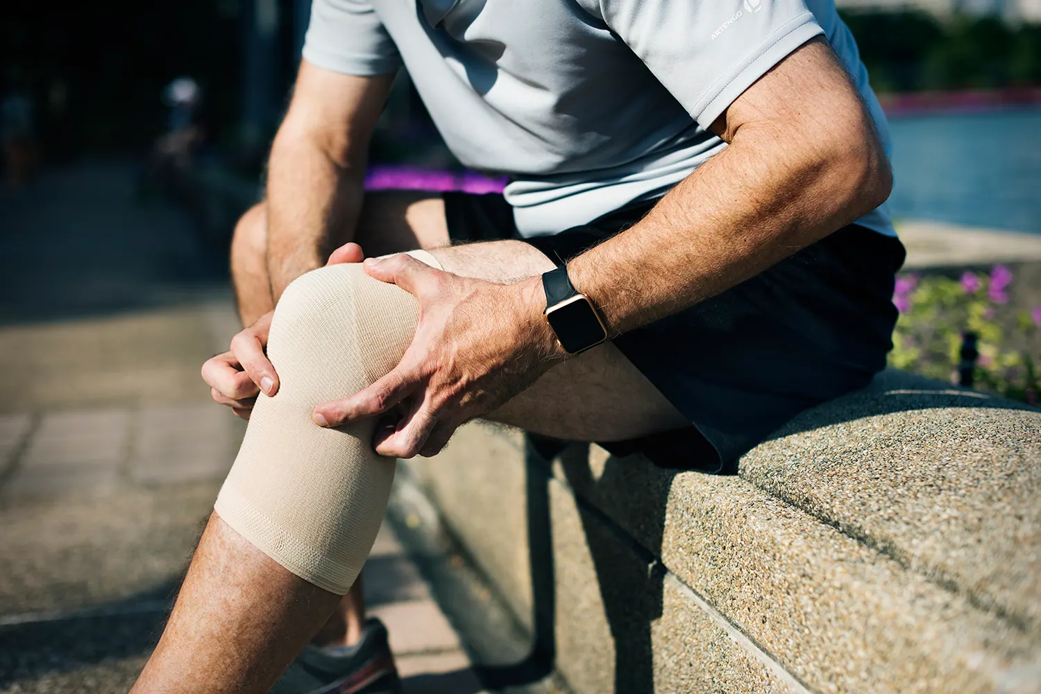 athlete man put bandage on his knee pain