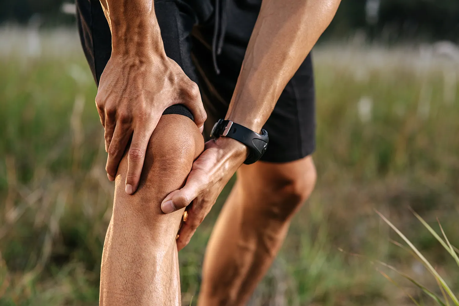 Runner holding his knee outdoors
