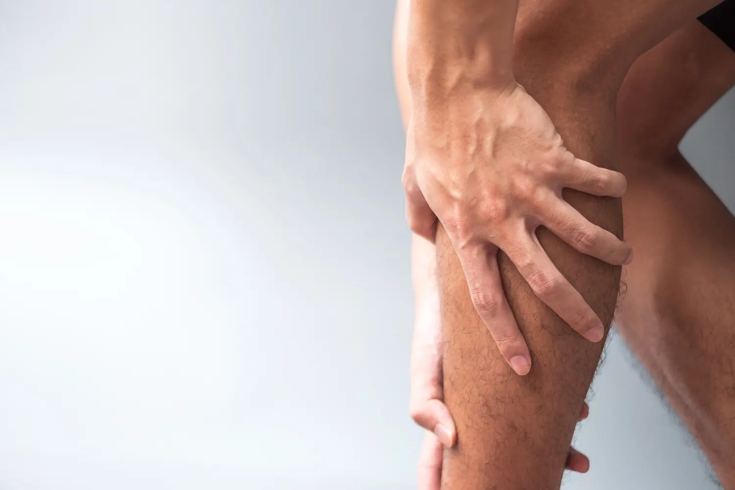 Man holding the back of his lower leg