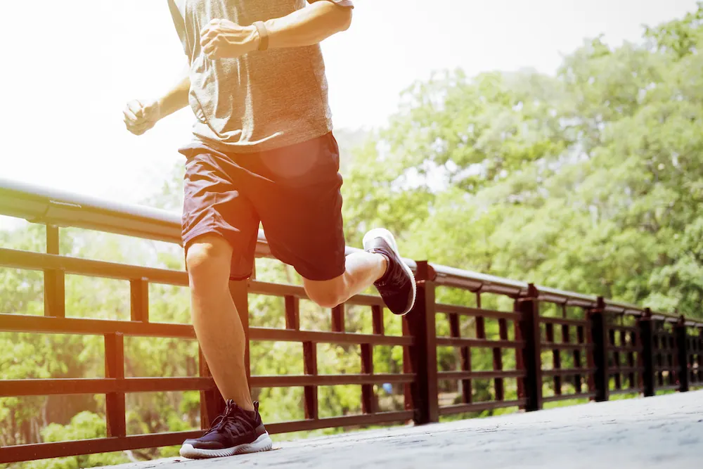 Runner jogging across a wooden footbridge