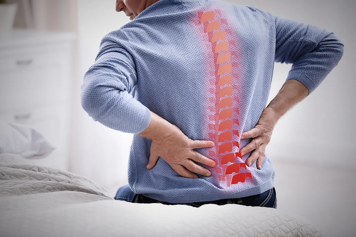 Man holding his lower back with the spine highlighted in red