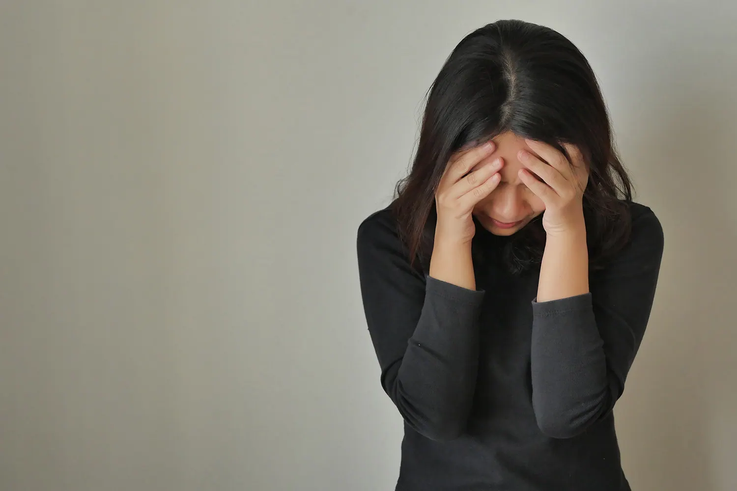 Woman holding her head in both hands